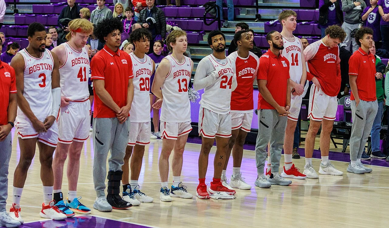 College basketball players gather on court before a game.