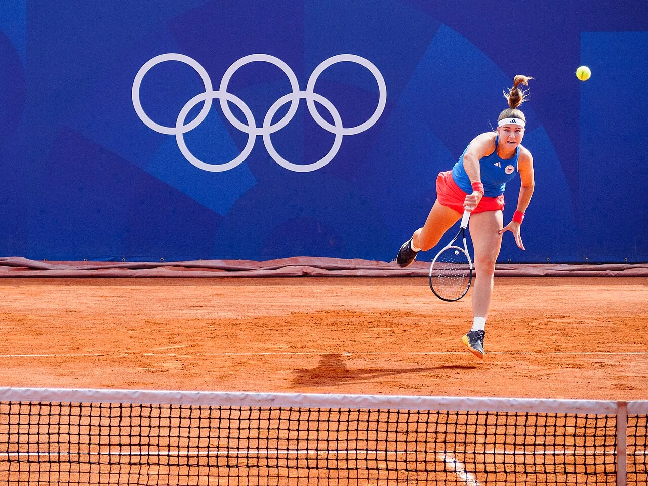 A tennis player prepares to return the ball on court.