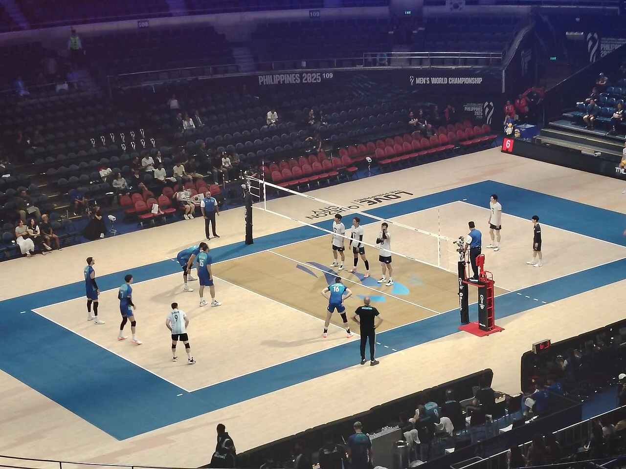 Players contest an indoor international volleyball match.