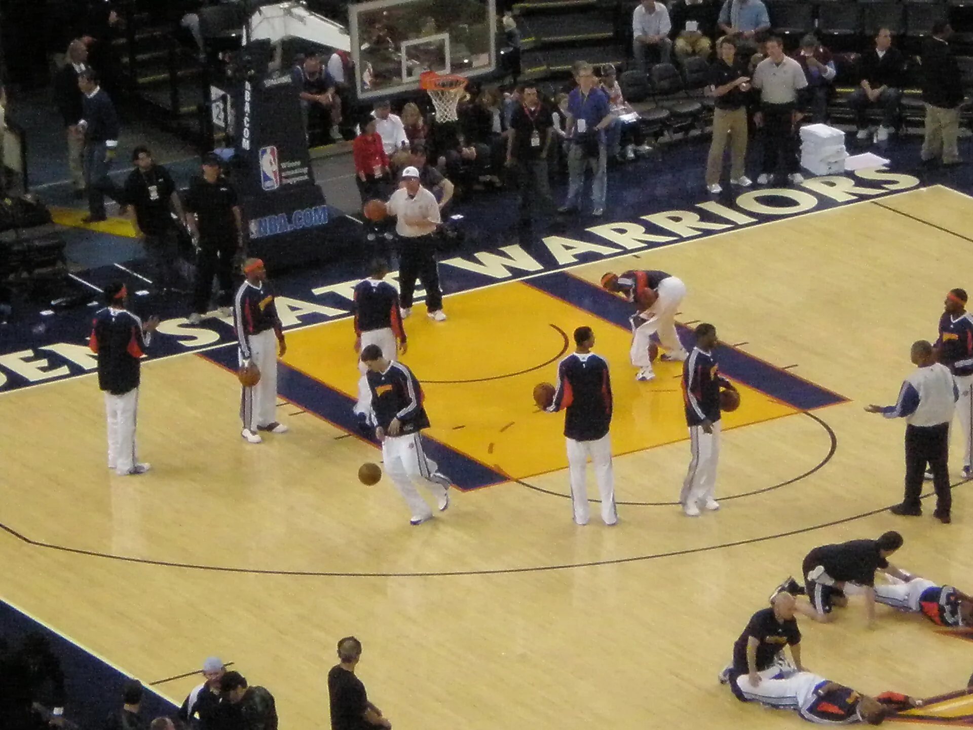 Golden State Warriors players warm up on court before a game.