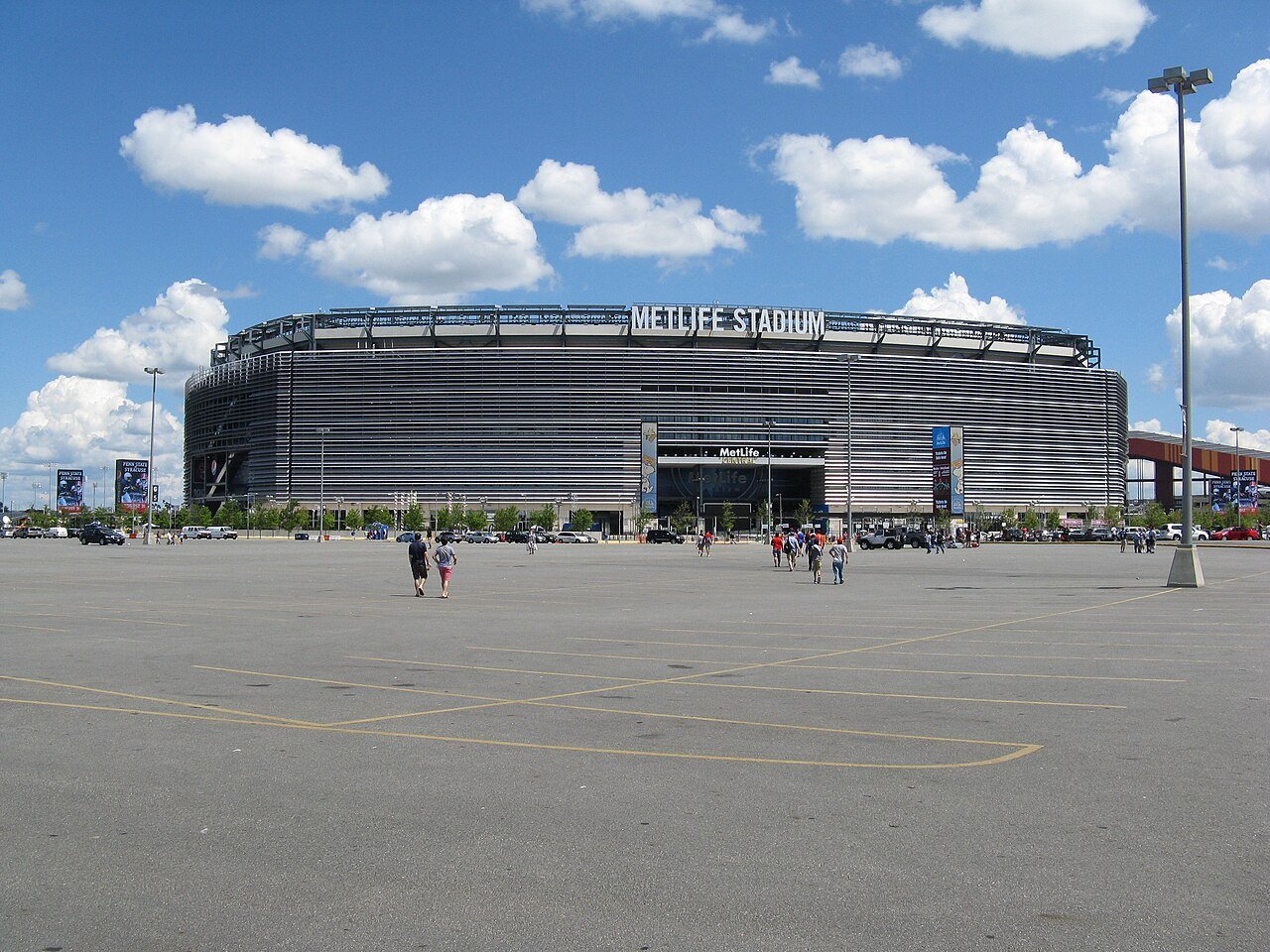 A football match fills New York New Jersey Stadium under bright lights.