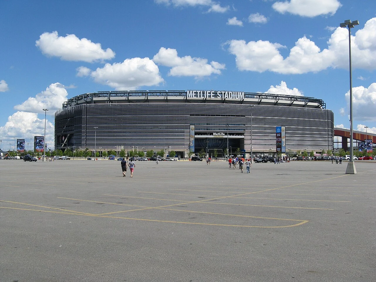 A football match fills New York New Jersey Stadium under bright lights.