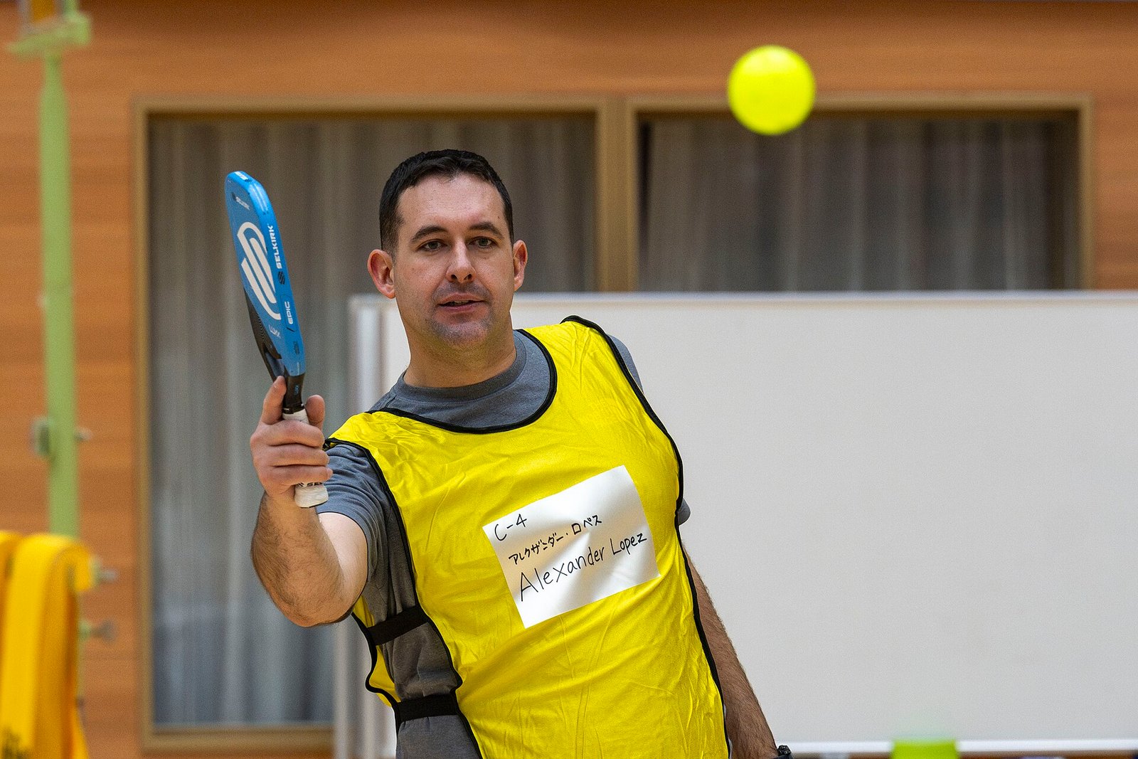 Pickleball players meet at the net during an international sport exchange.