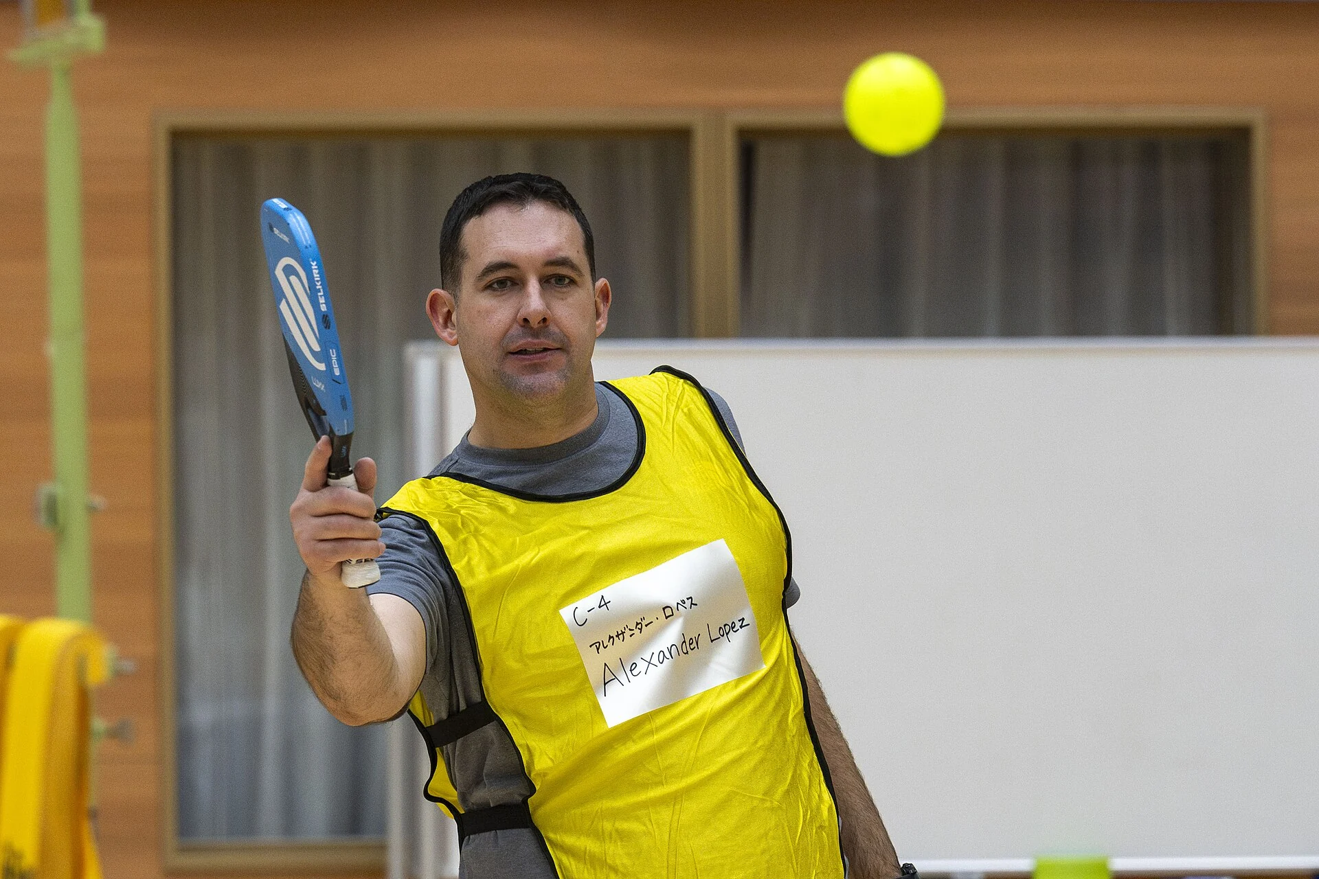 Pickleball players meet at the net during an international sport exchange.