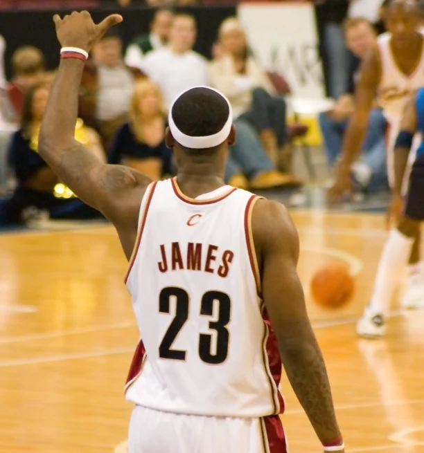 Professional basketball players compete in a packed indoor arena.