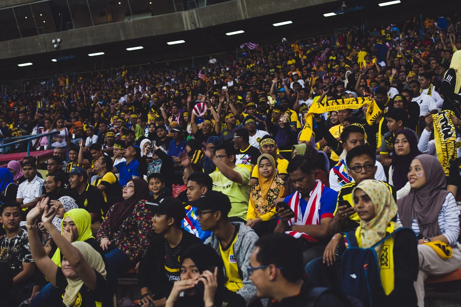 Malaysia football supporters fill a stadium stand.