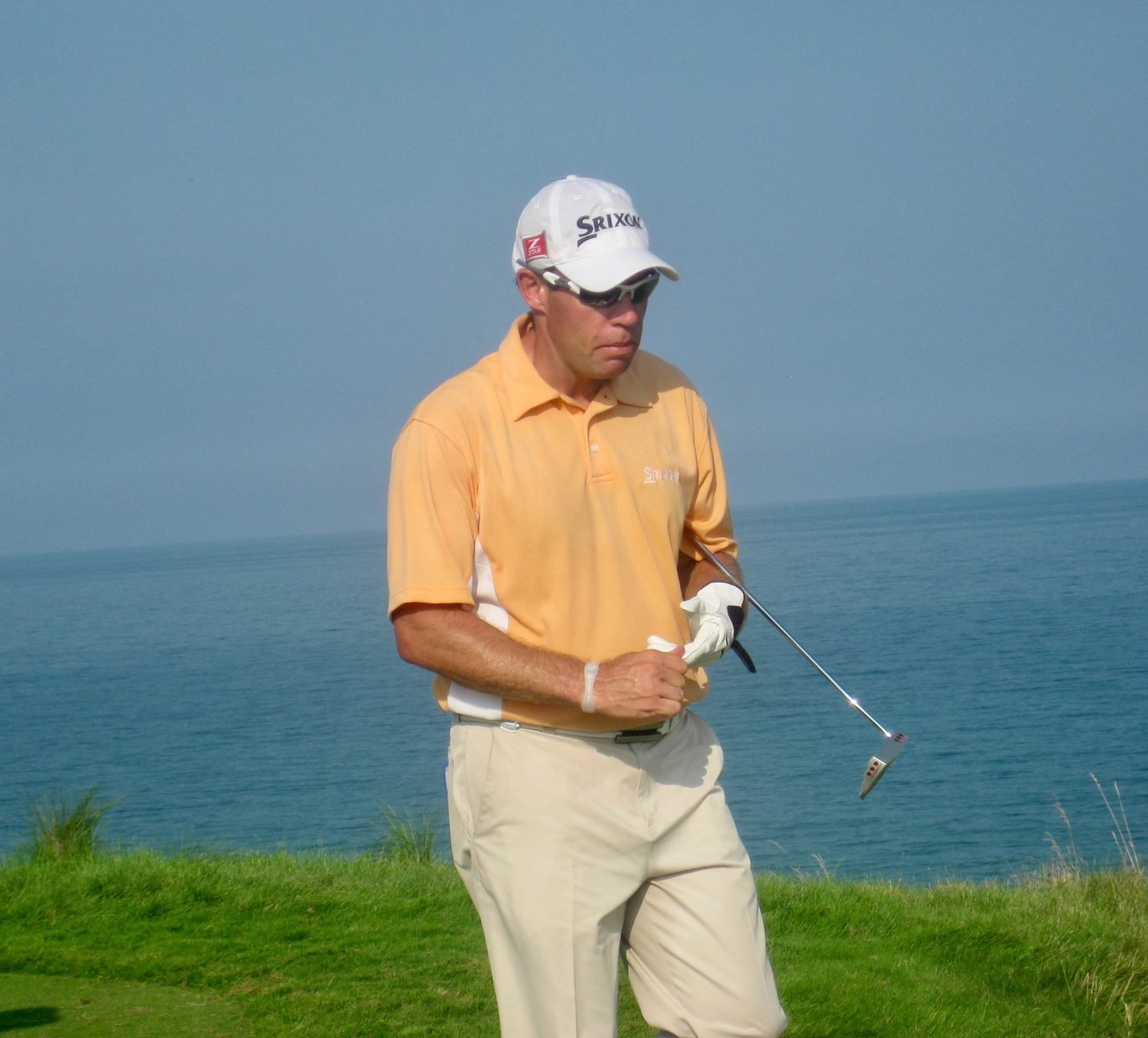 A professional golfer watches a shot during tournament play.