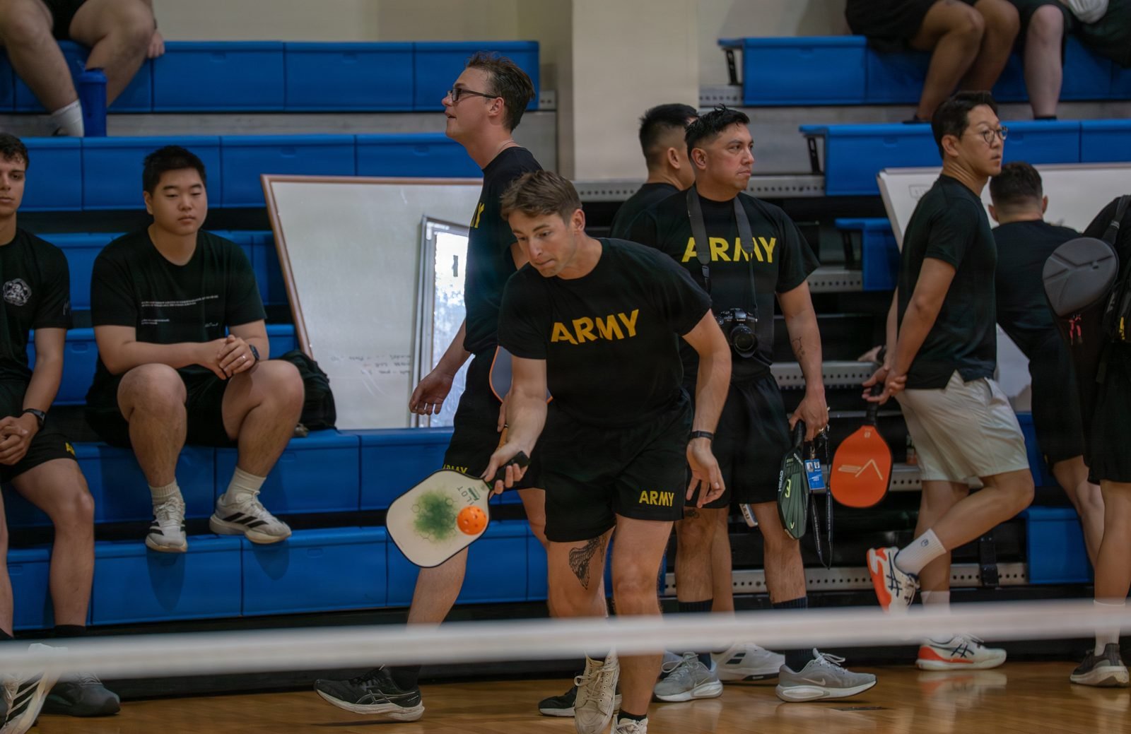 Players contest a doubles pickleball match during a community sports week.