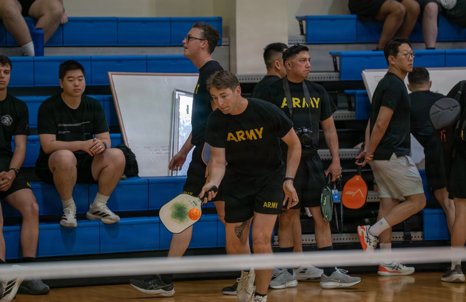 Players contest a doubles pickleball match during a community sports week.