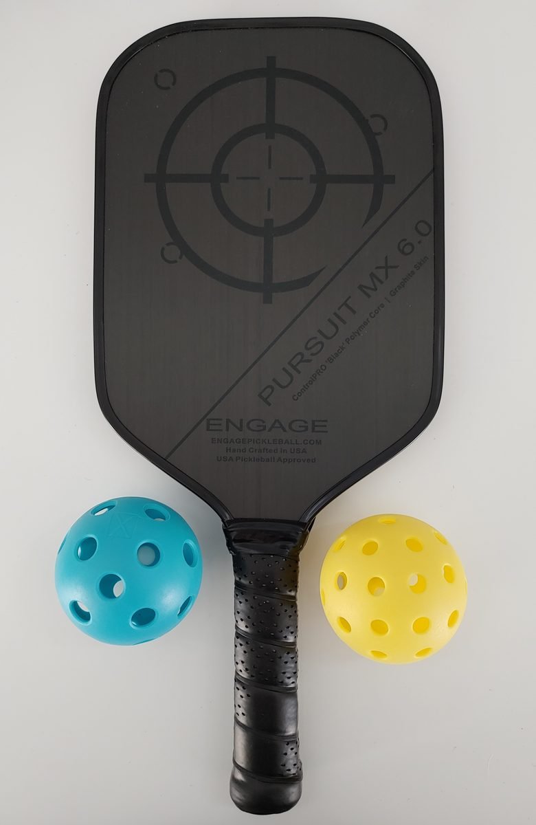 A pickleball paddle rests beside two pickleballs.