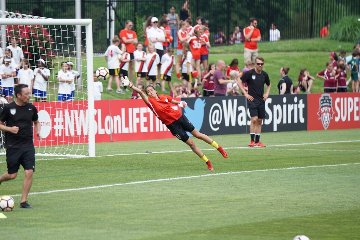 Football players competing on a pitch.