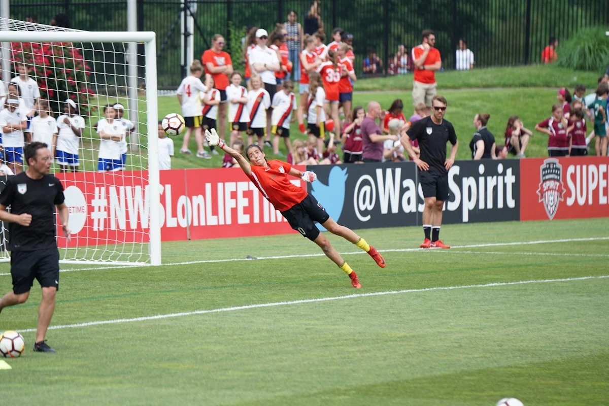 Football players competing on a pitch.