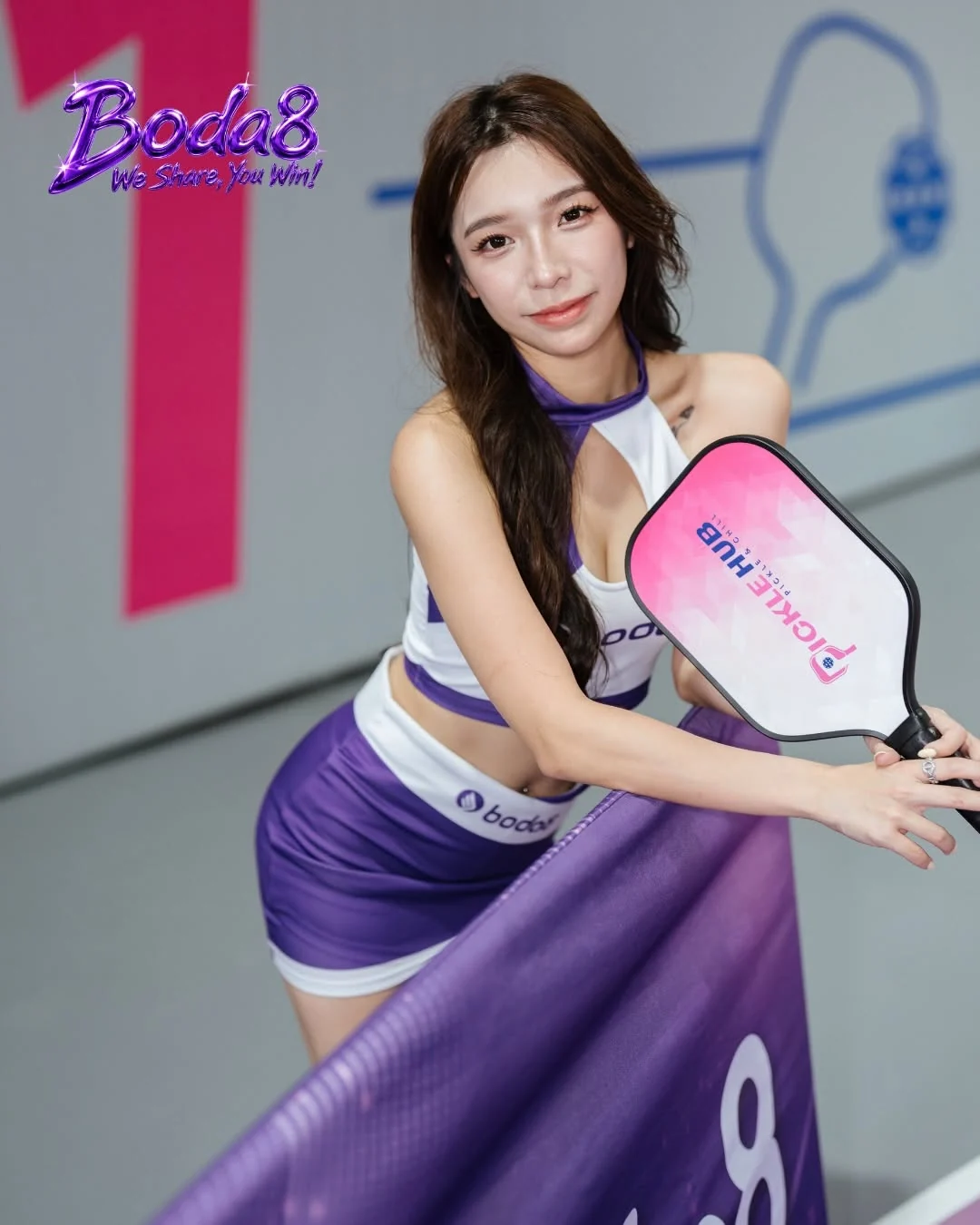 A Boda8 Sport representative posing with a pickleball paddle at the team event.