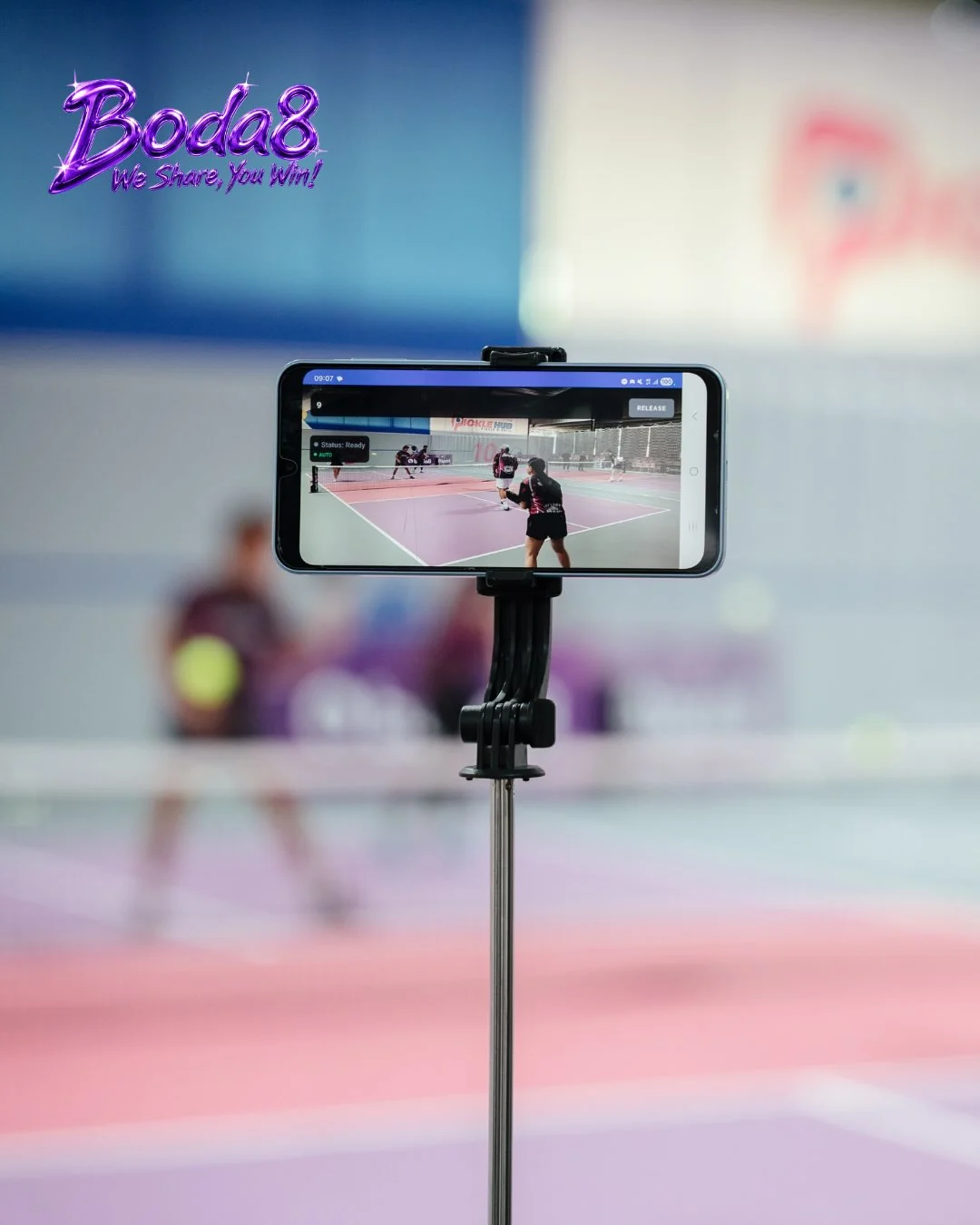 A Boda8 Sport representative posing courtside with a pickleball paddle during the Pickleball Team Event Tournament.